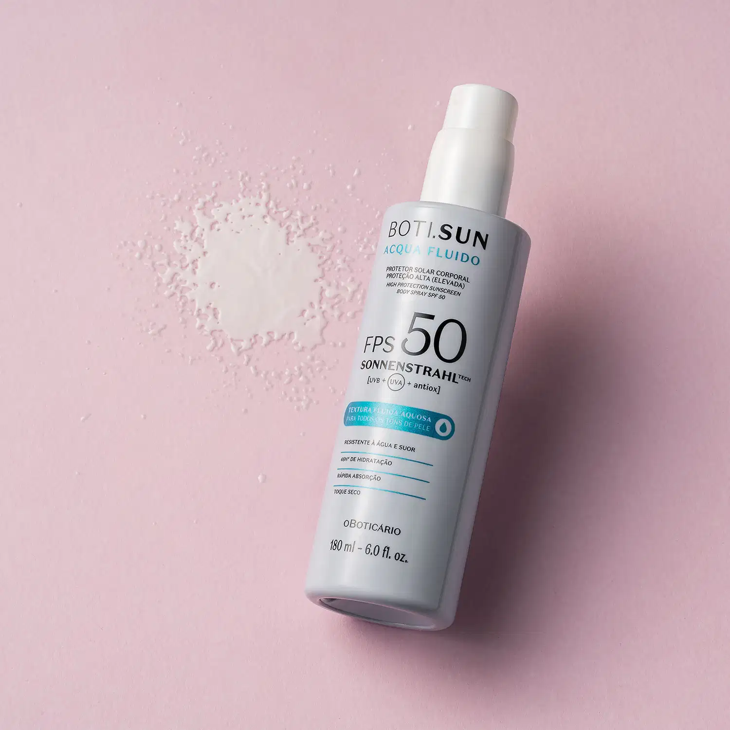 Frasco branco com tampa amarela de spray protetor solar corporal FPS 50 Acqua Fluído da marca Boti.Sun posicionado sobre superfície rosa claro, com pó branco espalhado ao lado, criando composição de produto em ambiente minimalista.