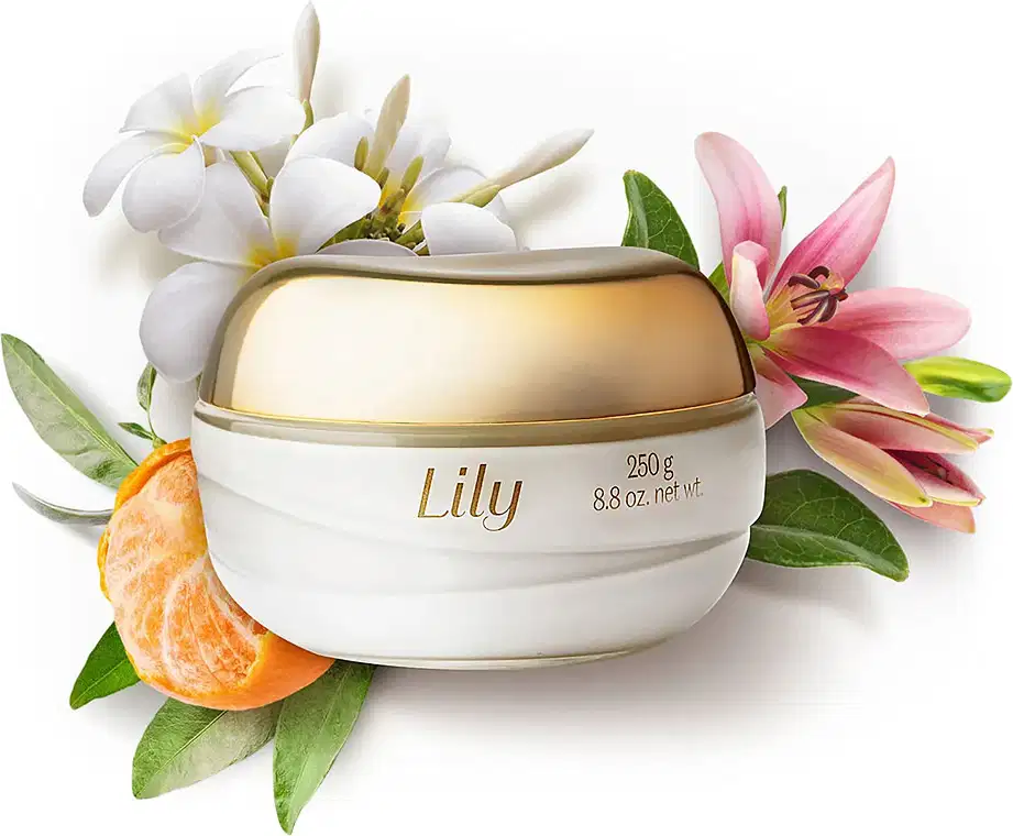 Pote de vidro transparente com conteúdo branco, tampa e letras douradas de creme acetinado hidratante desodorante corporal da marca Lily rodeado por lírios, flores brancas, folhas verdes e gomos de bergamota.