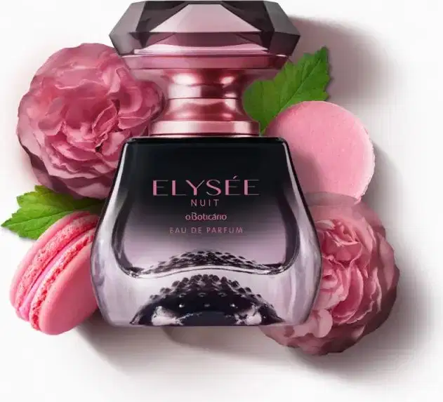 Vidro transparente em preto e transparente com borrifador e letras douradas, tampa transparente em formato de cristal lapidado de Eau de Parfum Elysée Nuit circundado por flores rosas, macarons rosa e folhas verdes sobre fundo branco.