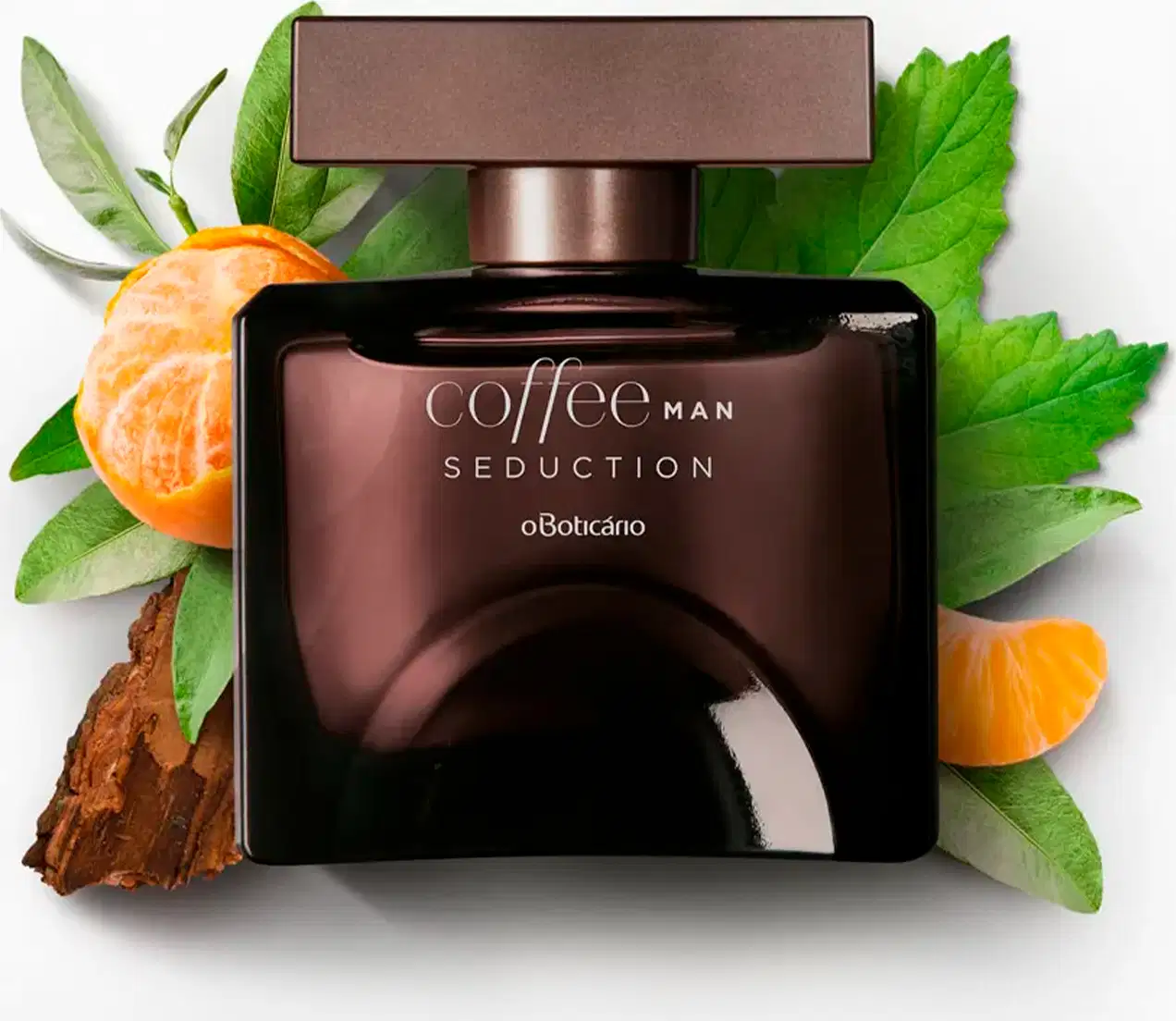 Frasco quadrado marrom com tampa retangular na mesma cor e letras cinzas, contendo desodorante colônia Coffee Man Seduction, circundado por folhas verdes, fatias de tangerina e casca de café em fundo branco.