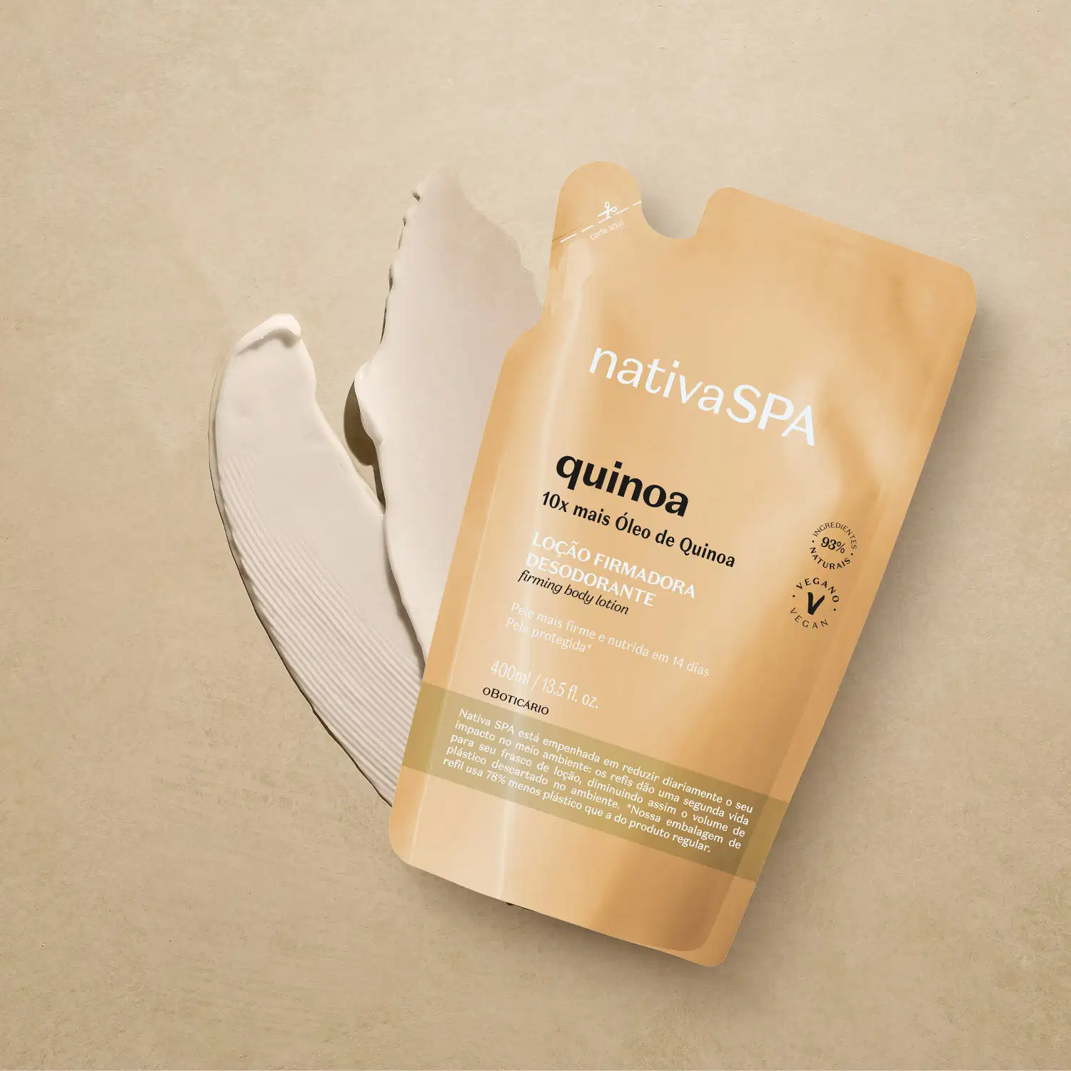 Refil de loção firmadora hidratante corporal Nativa SPA Quinoa em sachê de 400ml na cor bege  com letras douradas, pretas e brancas sobre superfície bege com creme branco ao lado, mostrando textura do produto.