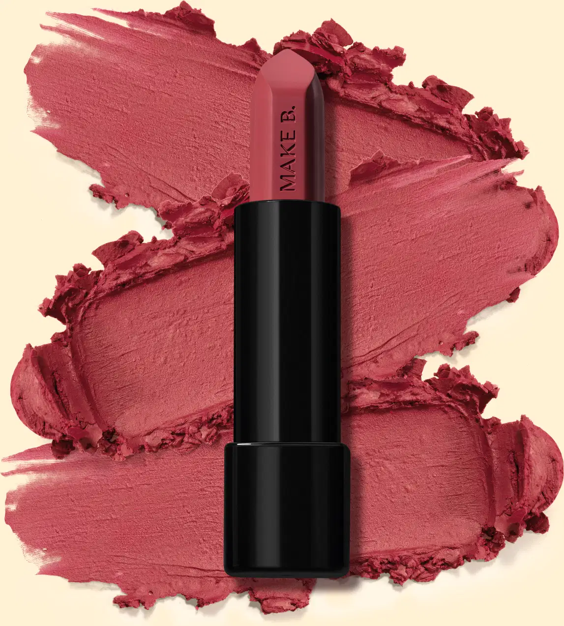 Batom mate na cor Rosa Rose Fabulous da marga Make B., em tubo preto posicionado sobre uma amostra do produto na cor rosa intenso, sobre fundo bege claro.