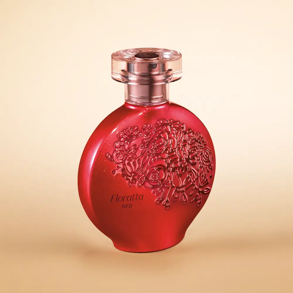 Perfume em frasco de vidro vermelho com detalhes em relevo floral. O frasco tem um formato arredondado e tampa rosada metálica. O frasco vermelho vibrante e os detalhes florais em alto relevo, sugerindo uma fragrância floral intensa.