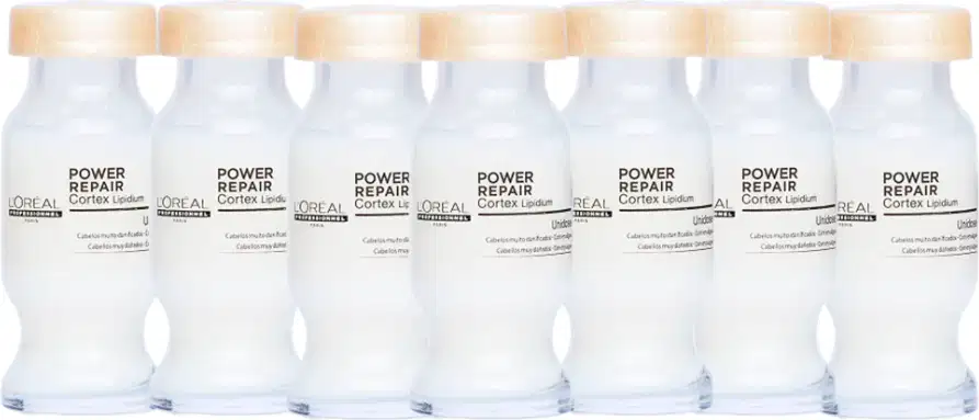Frascos brancos da linha Power Repair da L'Oréal Professionnel, com tampas douradas, exibindo o nome do produto em destaque. Os frascos estão alinhados em uma fileira, sugerindo uma apresentação de produtos de cuidados capilares.