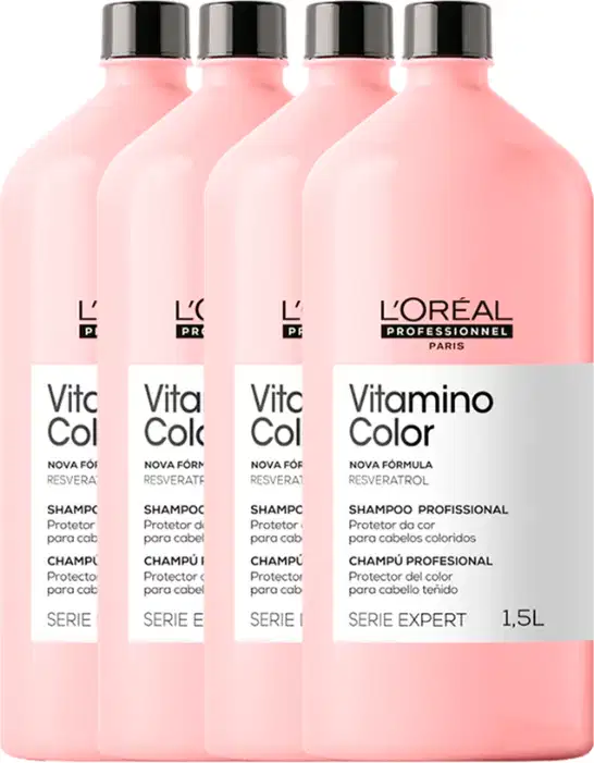 Quatro frascos de shampoo da linha Vitamino Color da L'Oréal Professionnel, com embalagem rosa e rótulos indicando a série e o tipo de produto para cabelos coloridos.
