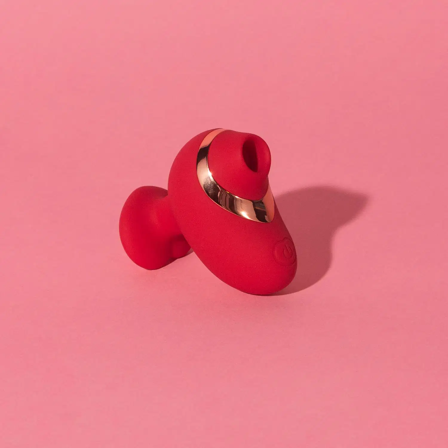Vibrador vermelho com acabamento metálico, em formato ergonômico e compacto, da marca Désir Atelier.