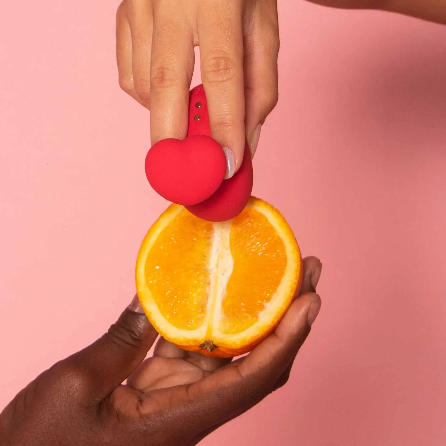 Mãos segurando uma laranja cortada ao meio e um acessório Désir Atelier