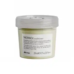 Frasco de condicionador Momo da marca Davines, com tampa transparente e rótulo branco com texto em preto. O produto contém extrato de melão amarelo e é indicado para cabelos secos ou desidratados.