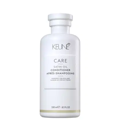 Frasco branco da linha Keune Care, contendo condicionador de óleo de cetim para cabelos opacos. Rótulo com o nome da linha "Care" e a descrição "Satin Oil Conditioner" em letras cinza.
