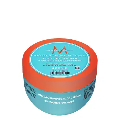 A imagem mostra a Máscara Capilar Moroccanoil Repair 250ml, um pote redondo de plástico na cor azul turquesa com detalhes em laranja. As informações sobre o produto estão escritas em inglês e espanhol no rótulo do pote.