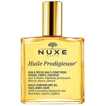 Frasco dourado de óleo multiuso da marca Nuxe, com rótulo em preto e amarelo indicando o nome "Huile Prodigieuse" e a descrição do produto como um óleo seco multifuncional para rosto, corpo e cabelos.