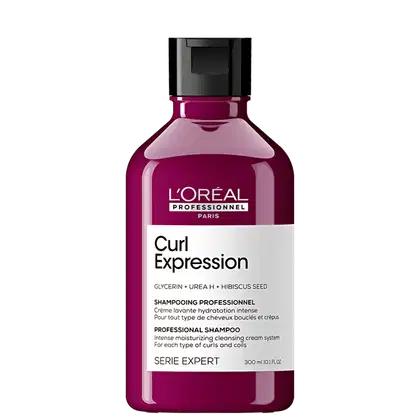 Frasco de shampoo profissional da L'Oréal Paris, da linha Curl Expression, com fórmula à base de glicerina, ureia e semente de hibisco, para cabelos cacheados e ondulados. Embalagem de plástico rígido de cor rosa escuro com rótulo branco e preto.