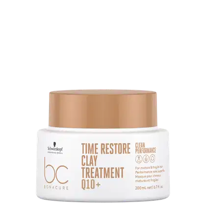 A imagem traz a máscara que vem em um pote branco com tampa bege de 200ml. Na embalagem, está escrito "Time Restore Clay Treatment Q10+" em letras marrons. Também está mencionado "Clean Performance".
