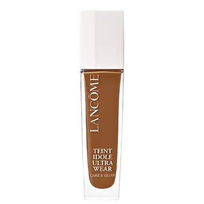 Frasco de maquiagem Lancôme Teint Idole Ultra Wear, com embalagem branca e tampa dourada. O rótulo destaca o nome do produto e suas características de "Care & Glow".