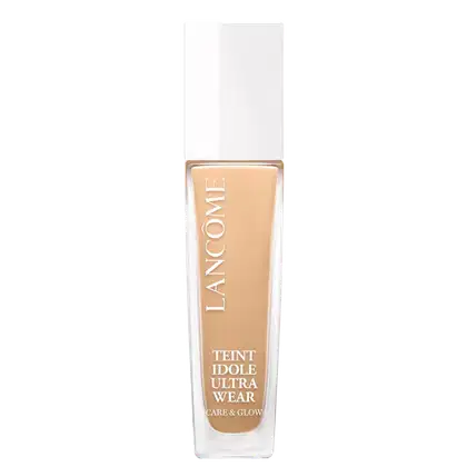 Frasco de maquiagem Lancôme Teint Idole Ultra Wear, com design minimalista em branco e dourado. O rótulo destaca o nome do produto e sua promessa de "Care & Glow", indicando uma fórmula de longa duração e acabamento radiante.
