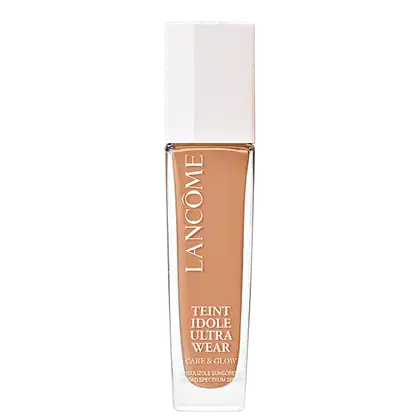 Frasco de maquiagem Lancôme Teint Idole Ultra Wear, com embalagem branca e detalhes em cobre. O produto é descrito como um "Care & Glow" com proteção solar FPS 15.