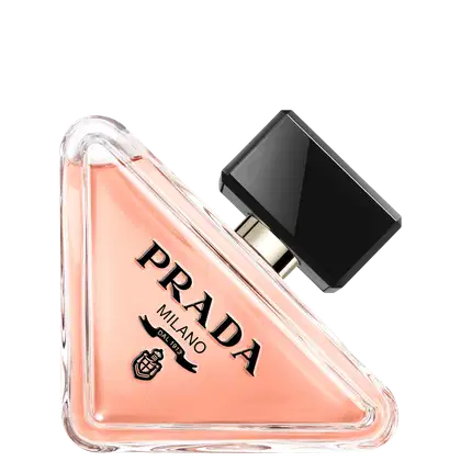 Frasco de perfume Prada com design triangular em vidro transparente, contendo líquido de cor rosa clara. O rótulo preto destaca o nome da marca "PRADA" em letras brancas.