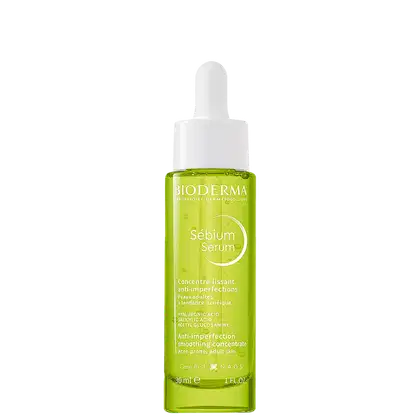 Frasco de vidro verde-limão com conta-gotas branco da linha Sebium Serum da Bioderma, um concentrado anti-imperfeições para peles adultas com tendência acneica. O rótulo destaca os principais ingredientes ativos, como ácido hialurônico e ácido salicílico.