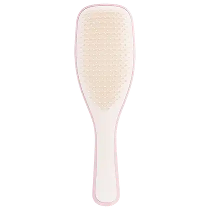 Escova de cabelo Tangle Teezer em formato alongado. Cabo plástico rosa claro. Superfície de escovação oval, texturizada com pequenos nódulos plásticos arredondados na cor bege claro. Design ergonômico para facilitar o penteado e desembaraçar os cabelos.