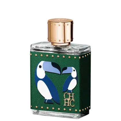 A imagem mostra um frasco de perfume, em formato retangular e feito de vidro transparente, com uma tampa dourada com detalhes e uma capa, cor verde, que cobre o frasco, com detalhes dourados e o desenho de dois pássaros azuis e a logo da marca em dourado.
