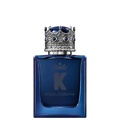 A imagem mostra o frasco do perfume K by Dolce&Gabbana. O frasco de vidro é na cor azul escura e tem forma retangular. A tampa é na forma de uma coroa prateada decorada com pedras azuis, e na frente, a imagem de uma coroa, a letra K e o nome da marca.