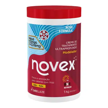 A imagem mostra o Creme de Tratamento Modelador Meus Cachos de Cinema 1kg, da marca Novex. O pote é vermelho com detalhes em branco e azul claro. O rótulo destaca que o produto promete "Força e renovação para cabelos com frizz" .