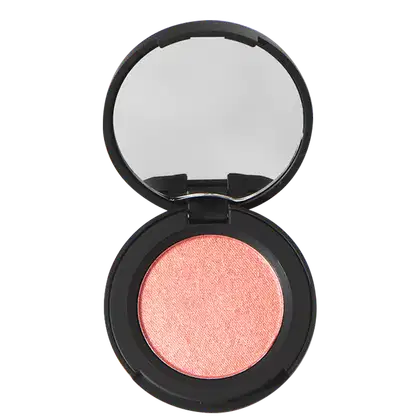 A imagem mostra um blush compacto Océane em uma embalagem preta redonda. O espelho embutido na tampa permite ver o brilho perolado da maquiagem rosa coral prensada dentro da base.