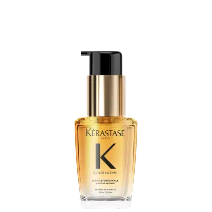 A imagem mostra o óleo capilar da marca Kérastase. O frasco é transparente, permitindo ver o líquido dourado dentro. O frasco tem um formato cilíndrico e uma bomba dosadora preta no topo. O rótulo apresenta letras pretas sobre um fundo dourado.