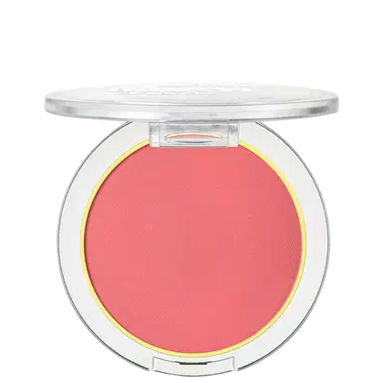 A imagem mostra um blush compacto de cor rosa em uma embalagem plástica transparente. O blush tem um acabamento fosco e está disposto em um estojo redondo. Em volta do pó compacto rosa, há um aro amarelo que realça a cor do produto.