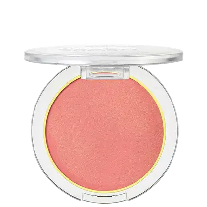A imagem mostra um blush compacto de cor rosa em uma embalagem plástica transparente. O blush tem um acabamento fosco e está disposto em um estojo redondo. Em volta do pó compacto rosa, há um aro amarelo que realça a cor do produto.