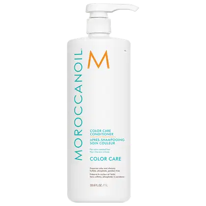A imagem mostra o Condicionador Color Care 1L da marca Moroccanoil. Embalagem plástica branca com bomba dosadora. logotipo da marca em laranja e detalhes do produto em turquesa e preto. Descrição indicando que preserva a cor e brilho dos cabelos coloridos
