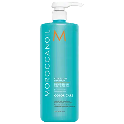 A imagem mostra o Shampoo Color Care 1L da marca Moroccanoil. Embalagem plástica na cor azul turquesa, com letras brancas e pretas e logotipo da marca em laranja. O frasco tem uma bomba dosadora branca na parte superior.