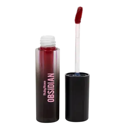 Batom líquido Ruby Rose na cor roxa, em frasco preto opaco. Ao lado, está o aplicador do batom com haste branca.