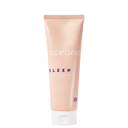 Embalagem tubular de plástico na cor bege claro. Rótulo com o nome "Océane Sleep Body Cream" e texto descritivo mencionando ingredientes como manteiga de karité, óleo de lavanda e extrato de camomila para relaxar.