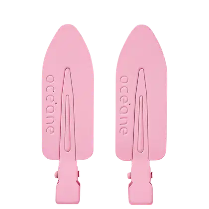 Duas presilhas cor rosa claro, com formato de seta e a marca "océane" grifada em relevo.