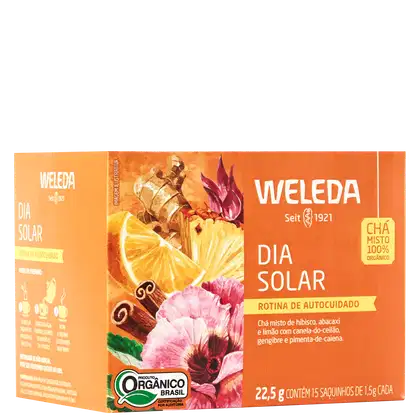 A imagem mostra a embalagem do chá em uma caixa retangular laranja com imagens de frutas cítricas, especiarias e flores. Texto em português descrevendo os ingredientes.