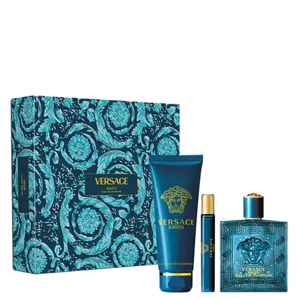 A imagem mostra um frasco de perfume azul com detalhes geométricos em relevo e a cabeça da Medusa Versace em dourado e um frasco menor do mesmo perfume. Uma caixa de presente com estampa floral azul e preta. Um tubo de gel de banho azul.