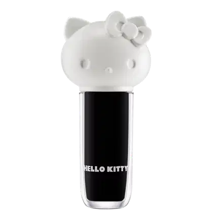 Maquiagem em formato cilíndrico com a cabeça da personagem Hello Kitty como tampa. A parte superior é branca com detalhes em relevo que representam os olhos, orelhas e laço da Hello Kitty. É possível ver a cor do produto pelo corpo transparente.