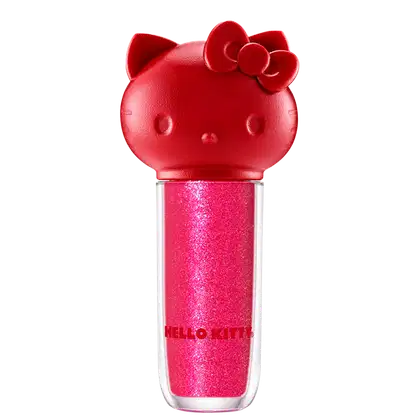 Maquiagem em formato cilíndrico com a cabeça da personagem Hello Kitty como tampa. A parte superior é vermelha com detalhes em relevo que representam os olhos, orelhas e laço da Hello Kitty. É possível ver a cor do produto pelo corpo transparente.