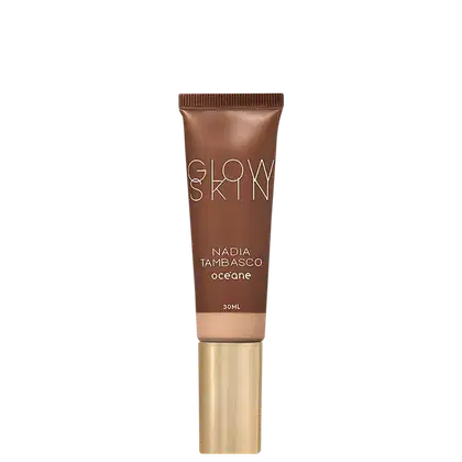 Tubo de maquiagem Glow Skin da marca Océane, com 30ml de volume, em embalagem marrom e dourada, com o nome da marca e da linha "Nadia Tambasco" impressos.