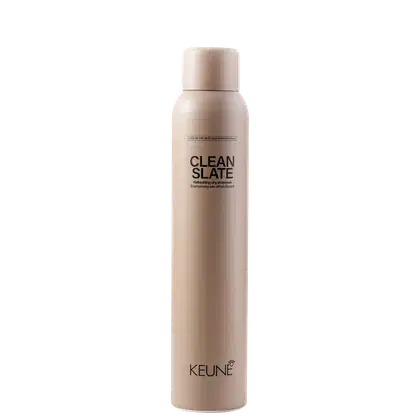 A imagem mostra o shampoo a seco Clean Slate da marca Keune. Frasco cilíndrico na cor bege claro com o texto "CLEAN SLATE" em letras maiúsculas pretas, descrevendo um "shampoo refrescante purificante" abaixo. O logotipo Keune aparece na parte inferior