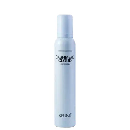 A imagem mostra a Mousse Keune Cashmere Cloud em frasco branco fosco. Embalagem cilíndrica com tampa protetora na cor azul claro. Nome do produto "Cashmere Cloud" e a marca "Keune" em letras pretas. Descrição adicional "Dry volumizing mousse"