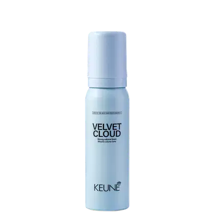 A imagem mostra a Mousse Volumadora Velvet Cloud da marca Keune. É apresentado em um frasco cilíndrico branco azulado opaco. Exibe o nome do produto "Velvet Cloud" em letras pretas maiúsculas, seguido da descrição "Mousse volume foam" em letras menores.