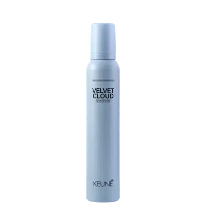 A imagem mostra a Mousse Volumadora Velvet Cloud da marca Keune. É apresentado em um frasco cilíndrico branco azulado opaco. Exibe o nome do produto "Velvet Cloud" em letras pretas maiúsculas, seguido da descrição "Mousse volume foam" em letras menores.