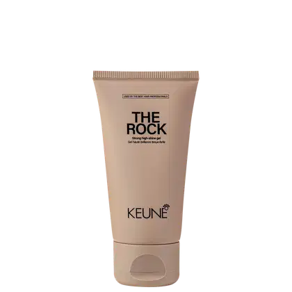 A imagem mostra o Gel de Cabelo The Rock da marca Keune. O produto vem em um tubo plástico na cor bege claro. Na parte superior está impresso em letras pretas "THE ROCK Strong high-shine gel".