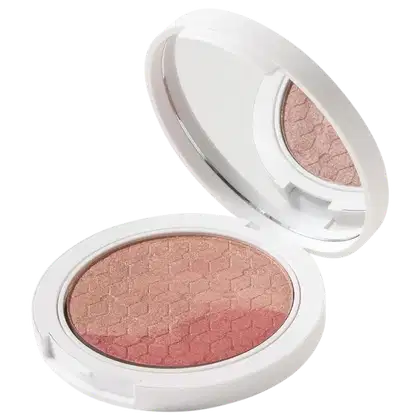 Blush em Pó Multifuncional em embalagem redonda branca. A parte interna removível revela uma superfície de pó prensado em tom rosado terroso.