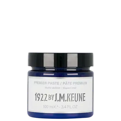 Pasta modeladora da marca Keune, com design moderno e rótulo branco com texto preto. Contém 100 ml do produto "Premier Paste" com acabamento fosco, conforme indicado na embalagem.