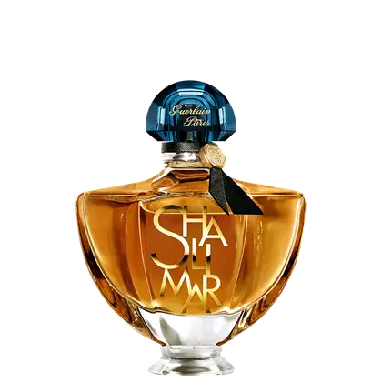 Frasco de perfume Guerlain Paris com tampa de cristal azul e rótulo dourado com a inscrição "Shalimar". Embalagem de vidro âmbar com design elegante e clássico.