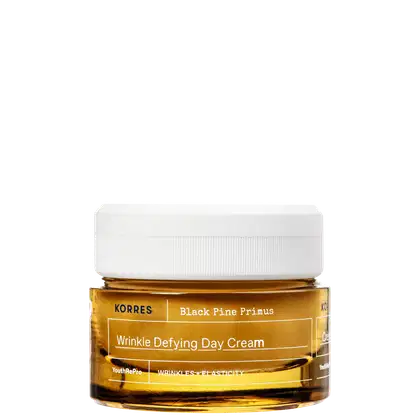 Frasco de creme antienvelhecimento da marca Korres, com rótulo amarelo e branco, contendo a descrição "Wrinkle Defying Day Cream" e "Black Pine Primus".