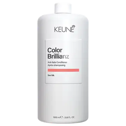 Frasco branco da linha Color Brillianz da Keune, um condicionador anti-fade para cabelos coloridos. O rótulo apresenta o nome da marca e do produto, além da informação "Sea Silk" sobre a fórmula.